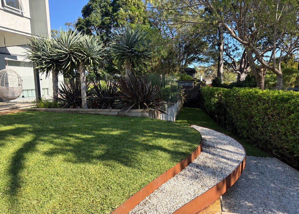 Curved Corten steel edging framing lawn & gravel paths
