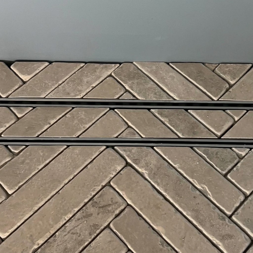 Slot drain set into herringbone tumbled tiles