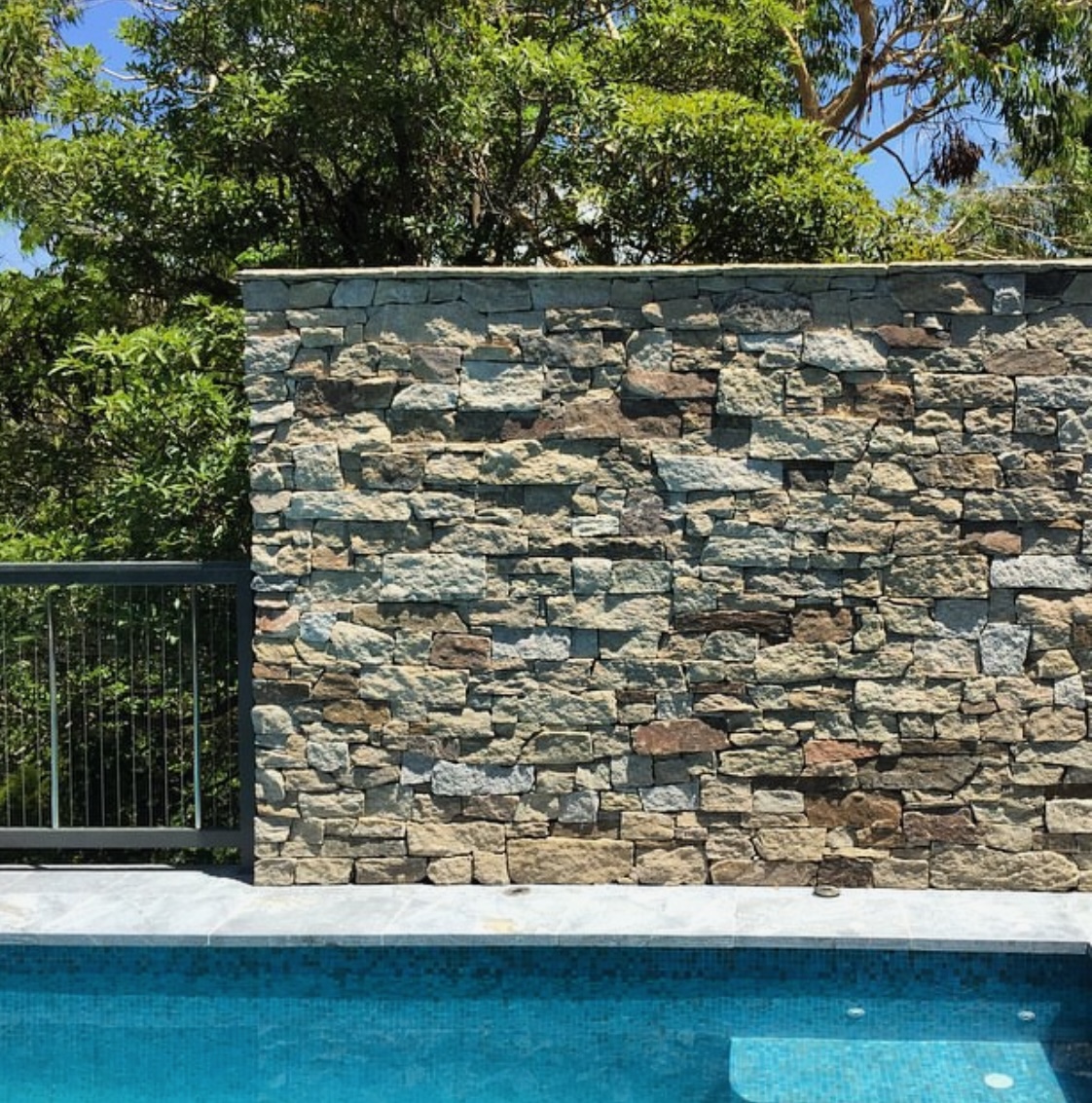 Poolside dry-stack stone wall