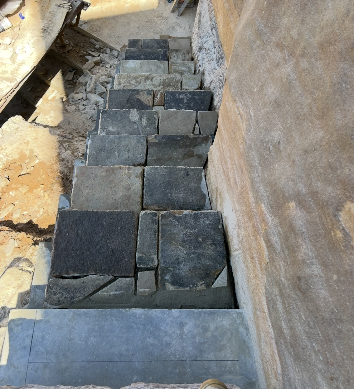 Bluestone block steps beside a sandstone wall