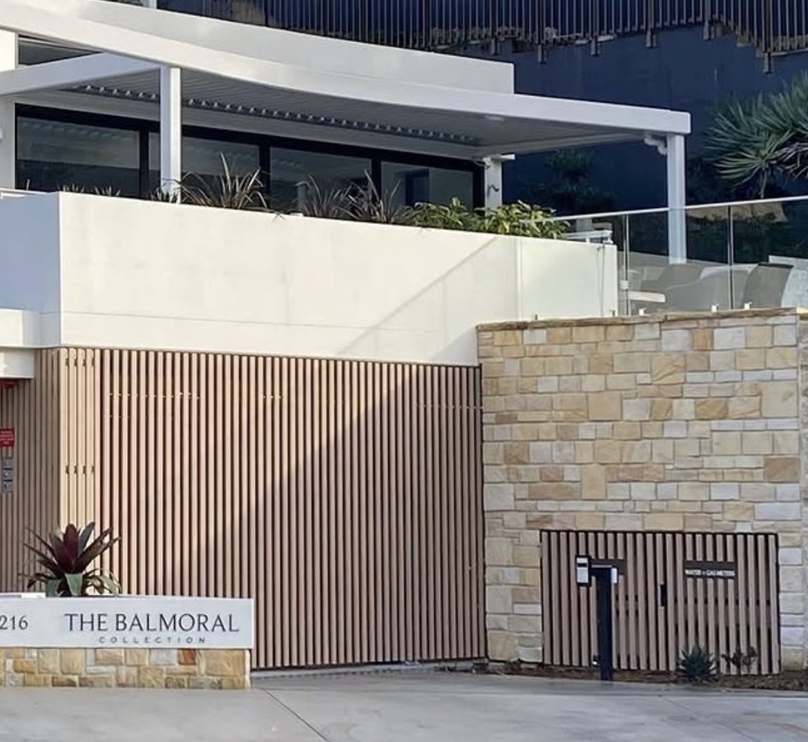 Sandstone entry wall with timber screen gates