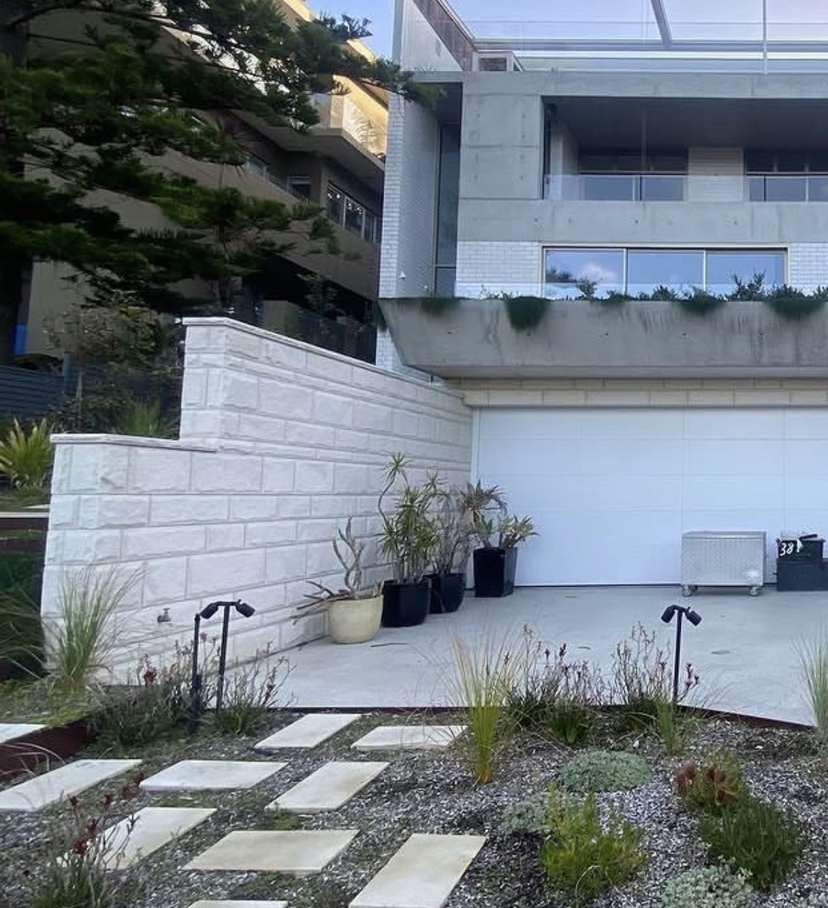 Sandstone-clad wall with stepping-stone garden